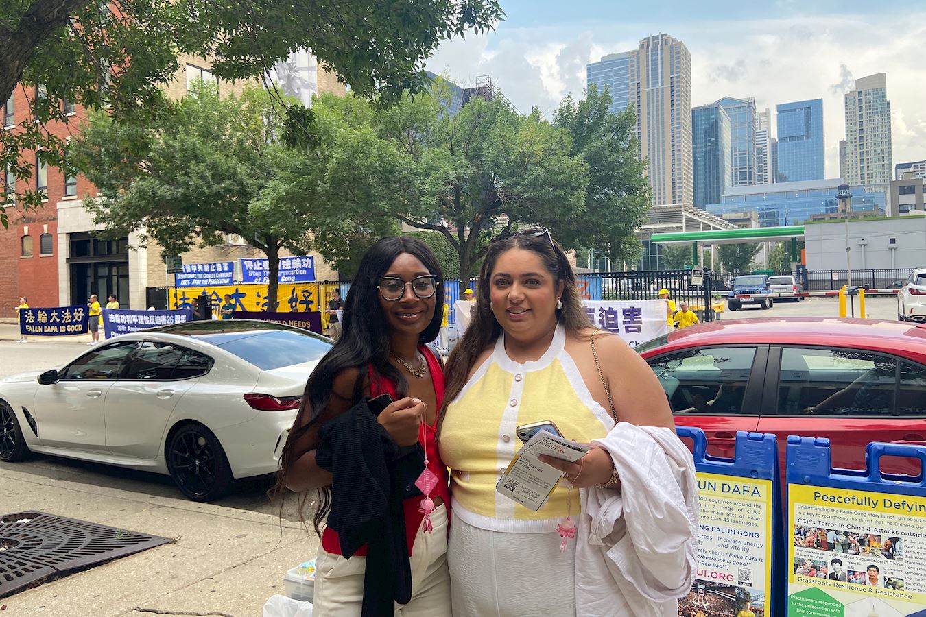 '图9:布莉娅·多尔西(左)和纳芙普丽特·达利瓦尔(右)寻着炼功音乐声来到法轮功抗议现场。'