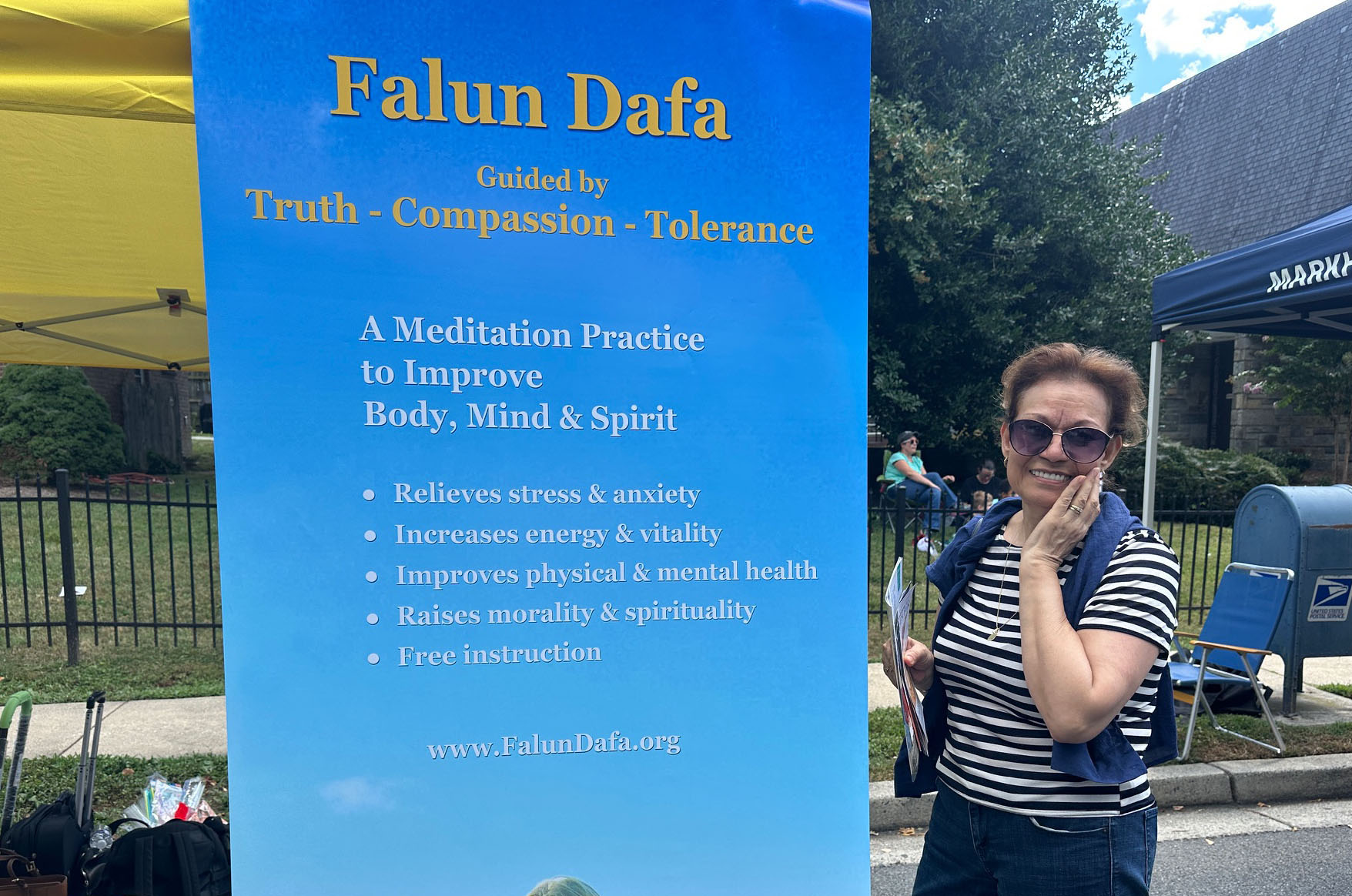 图13:梅拉(Mayra)来到法轮功展位拿取真相资料。