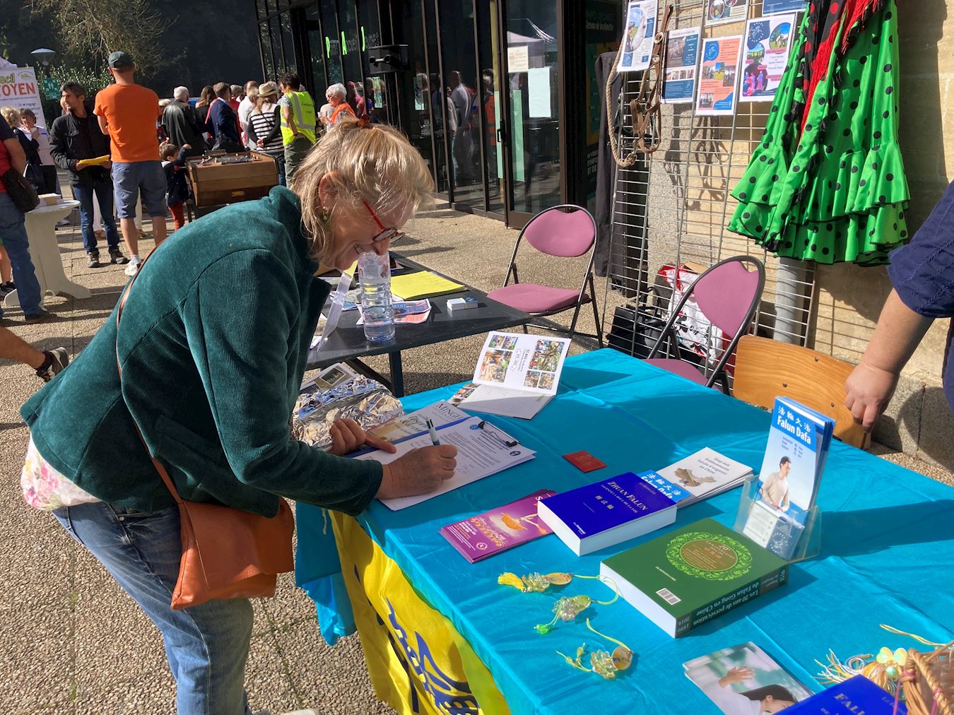 '图1~4:库唐斯市市民在真相展位上了解信息,并签名呼吁停止迫害法轮功。'