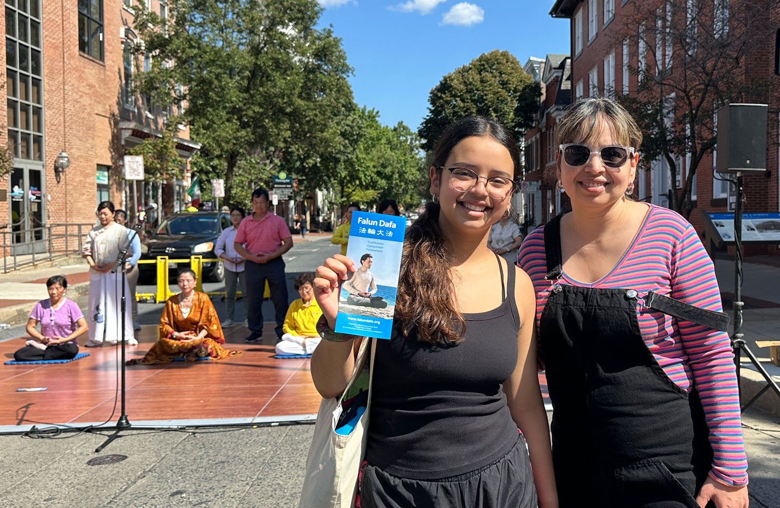 图7:伊丽莎白(左)和妈妈一起观看了法轮功学员的功法演示。