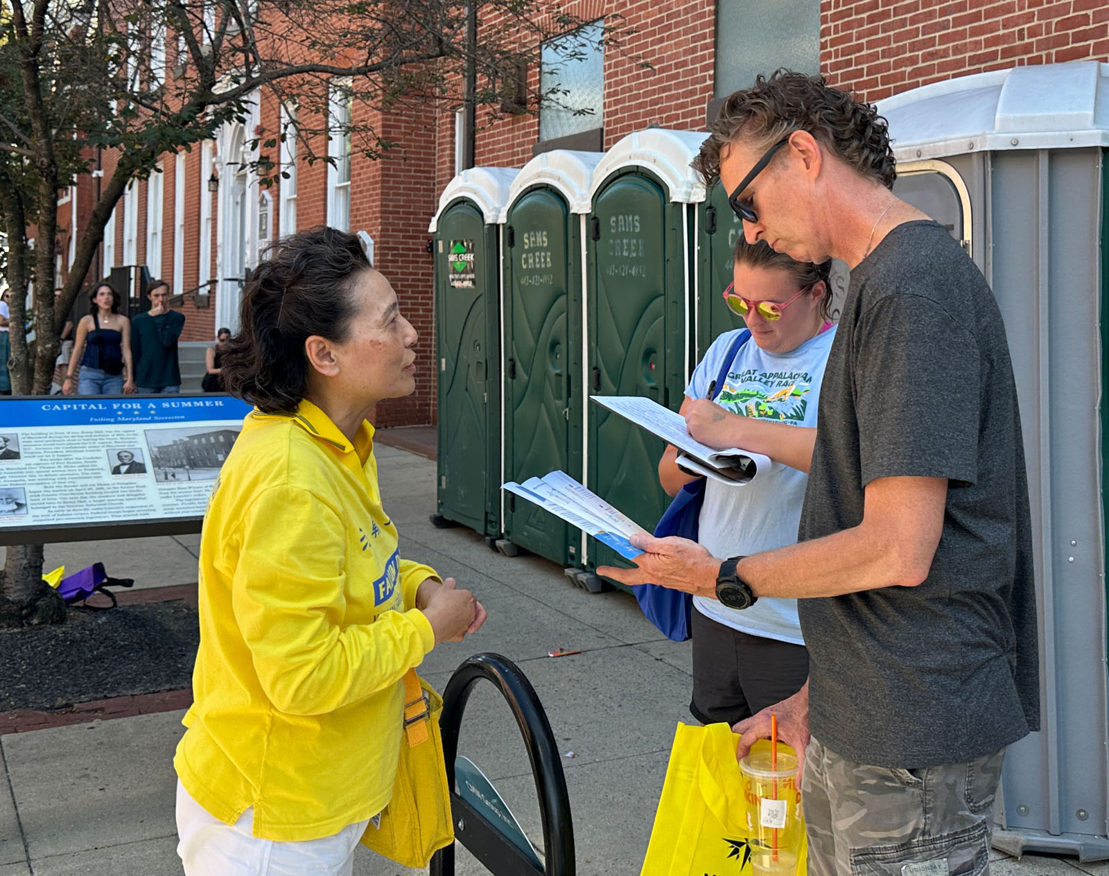 图9:杰基(右一)和梅纳德了解真相后,签名声援法轮功学员。