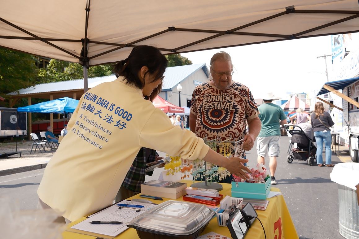'图1~3:法轮功学员在纽约上州卡纳乔哈里(Canajoharie)历史古镇的街会上向民众讲真相。'