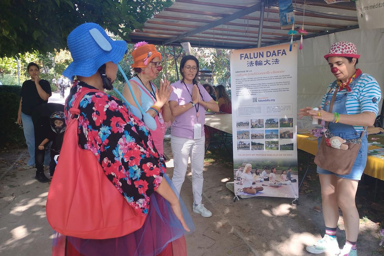 '图8:“社区共享”协会的喜剧演员们来到法轮功展位前,开始学炼功法。'