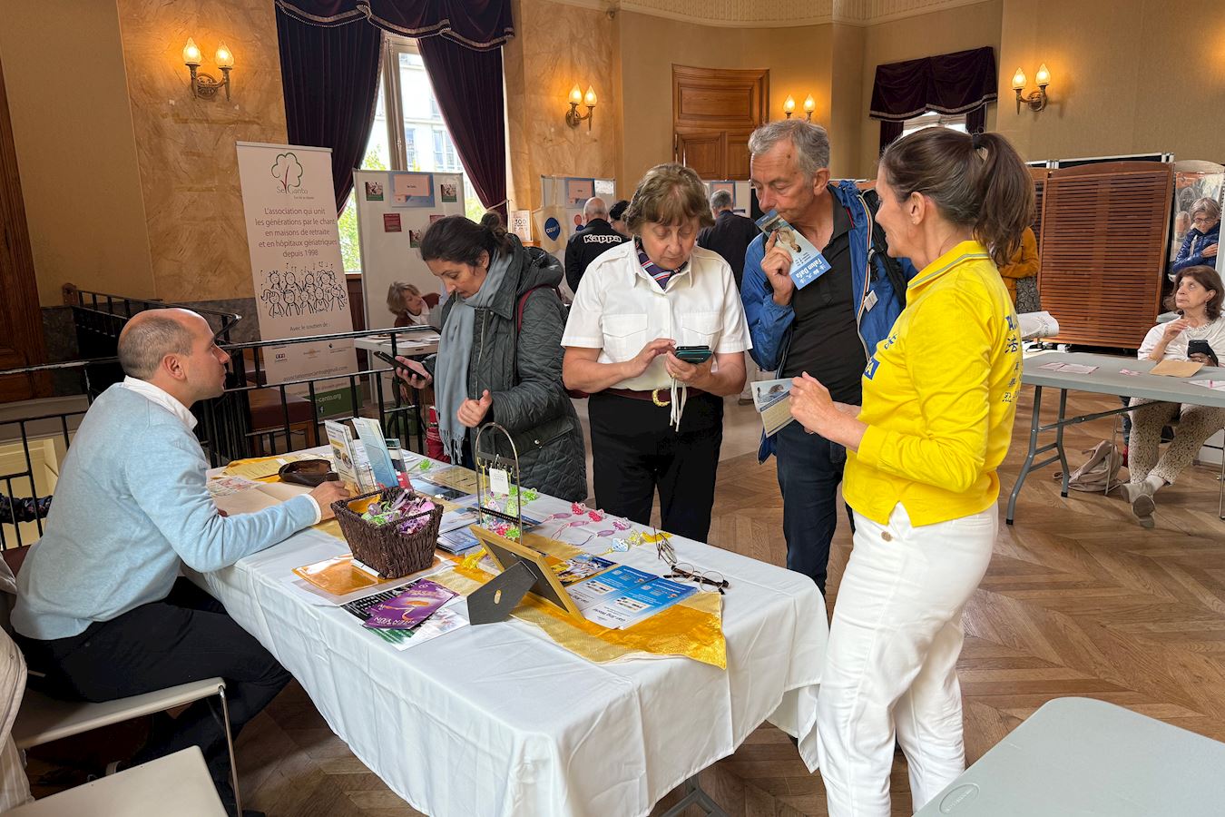 '图16~18:九月十三日,法轮功学员在巴黎十五区宴会厅举行的协会论坛上向人们介绍法轮功。'