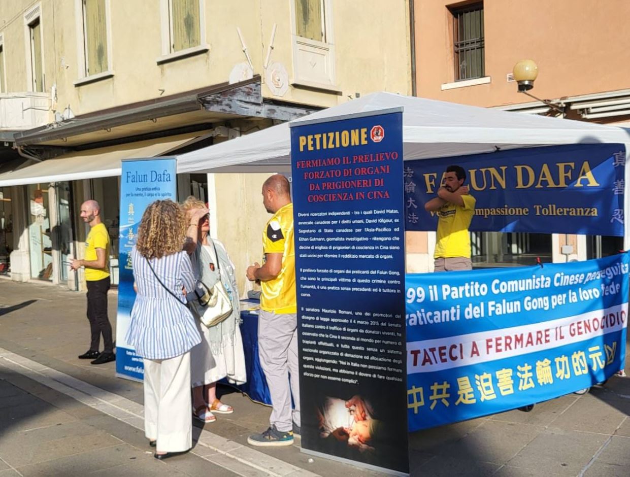 '图8~10:在梅斯特雷城(Mestre)法轮功学员向过往民众介绍法轮功'