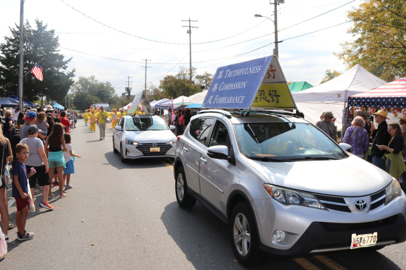 图3~4:二零二五年九月二十日,美国马里兰州一年一度的普尔斯维尔日游行,真相车队车顶上的展板向人们传递法轮大法的真相。