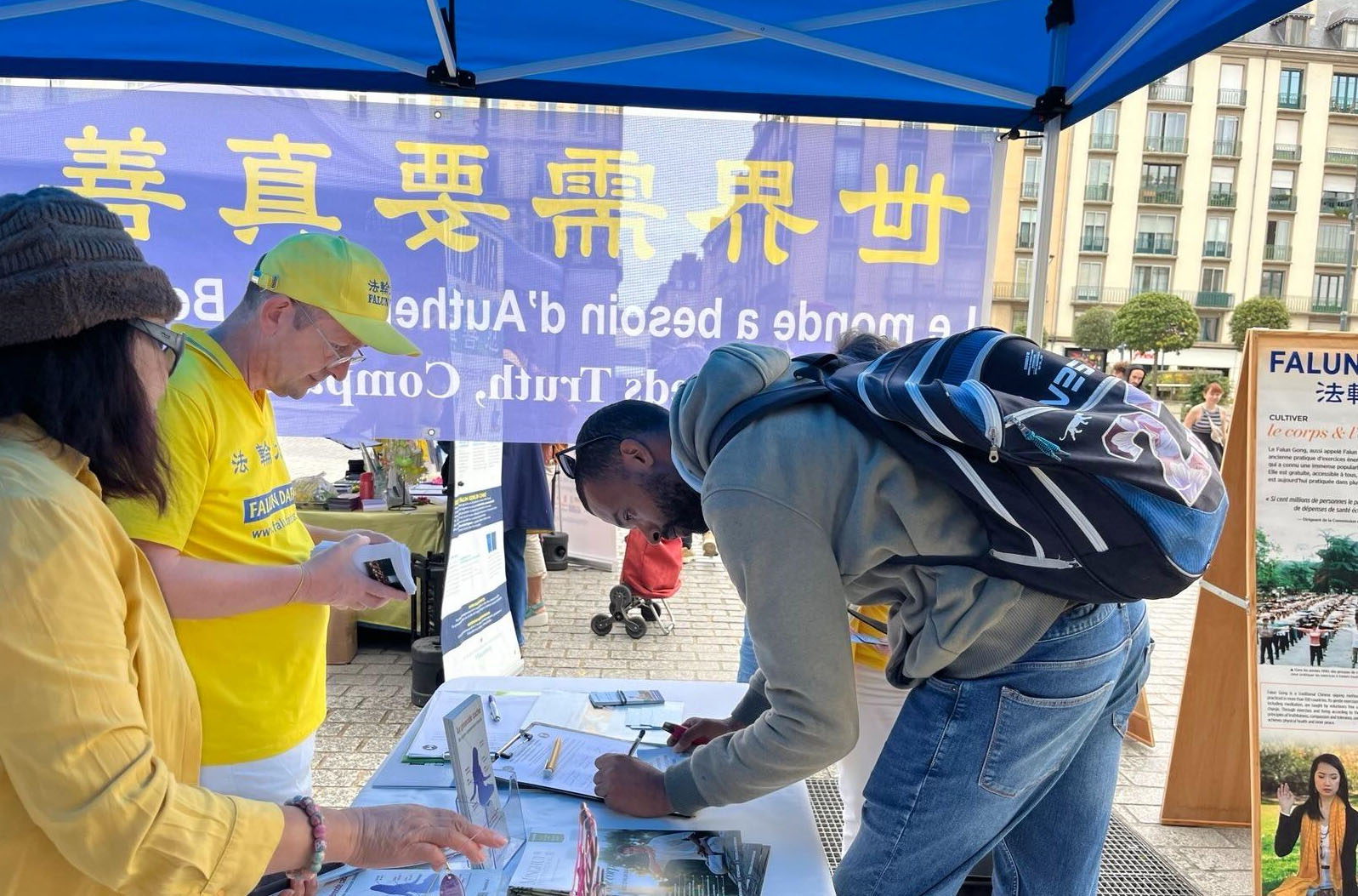 图3:人们在呼吁G7+7国家反对中共活摘器官请愿书上签字,支持法轮功学员的反迫害行动。