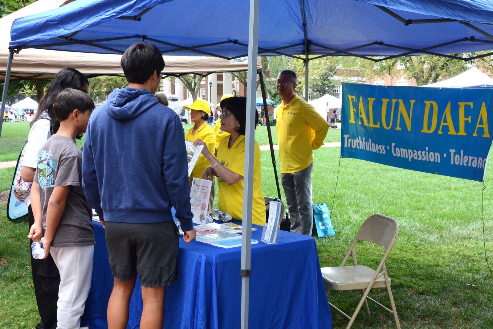 图1:二零二五年九月二十一日纽瓦克社区日,民众在法轮功展位前了解真相