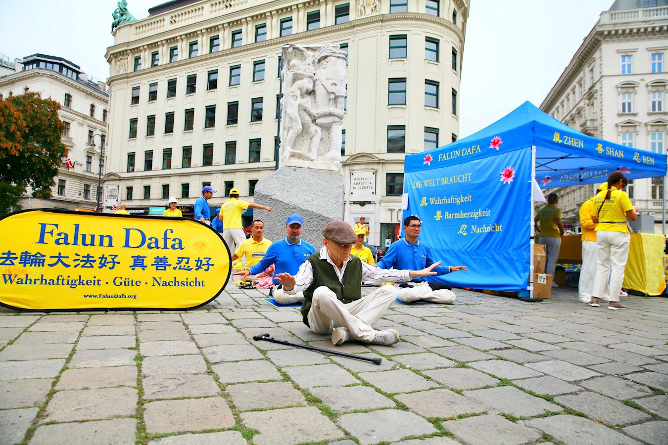 '图7:一位游客老先生放下拐杖,体验打坐。'