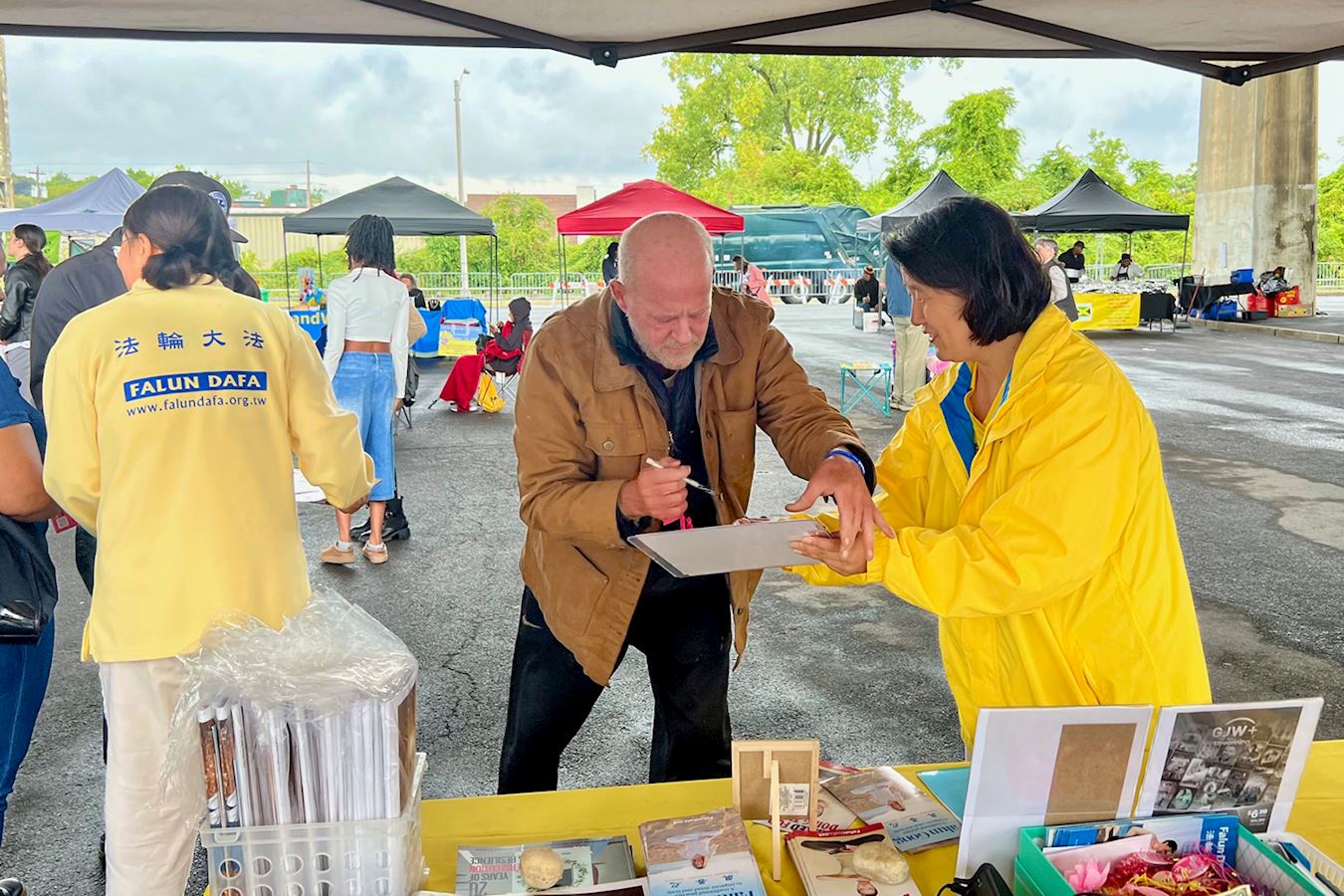 '图10:一位中文流利的长者在参议院议案《法轮功保护法案》的请愿书上签名,表示支持。'